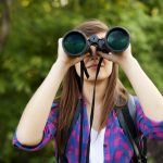 young-girl-looking-through-binoculars