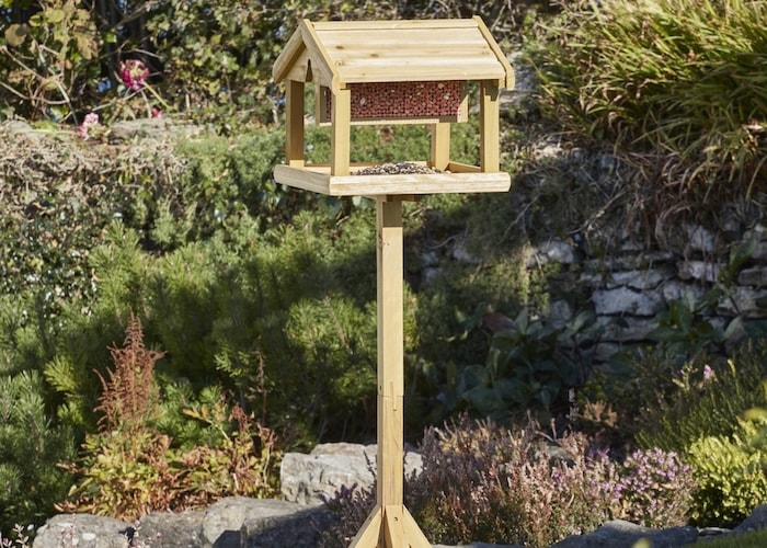 Wooden bird feeder with seeds and nuts