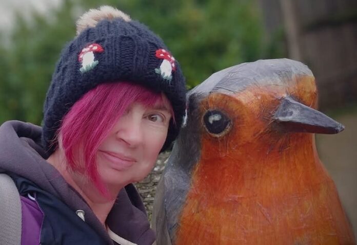 Female birdwatcher with robin statue